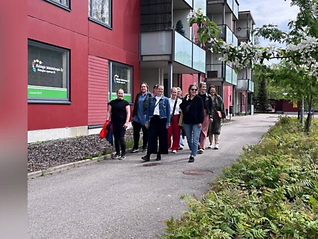 Helsingin Toimintaterapian henkilökunta kävelee yrityksen toimipisteen edessä